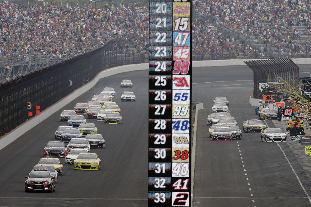 Cars on different pit strategies enter pit lane while others stay on the track in a caution period during the NASCAR Brickyard 400 auto race at Indianapolis Motor Speedway in Indianapolis on Sunday.