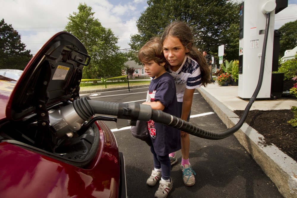 Luis Frederick Robinson, 4, and his sister Kerry-Elizabeth, 8, watch an electric car get quick-charged at a charging station that opened at the South Portland Community Center last week. Installing more chargers eases motorists’ concerns that their battery will run down and leave them stranded.