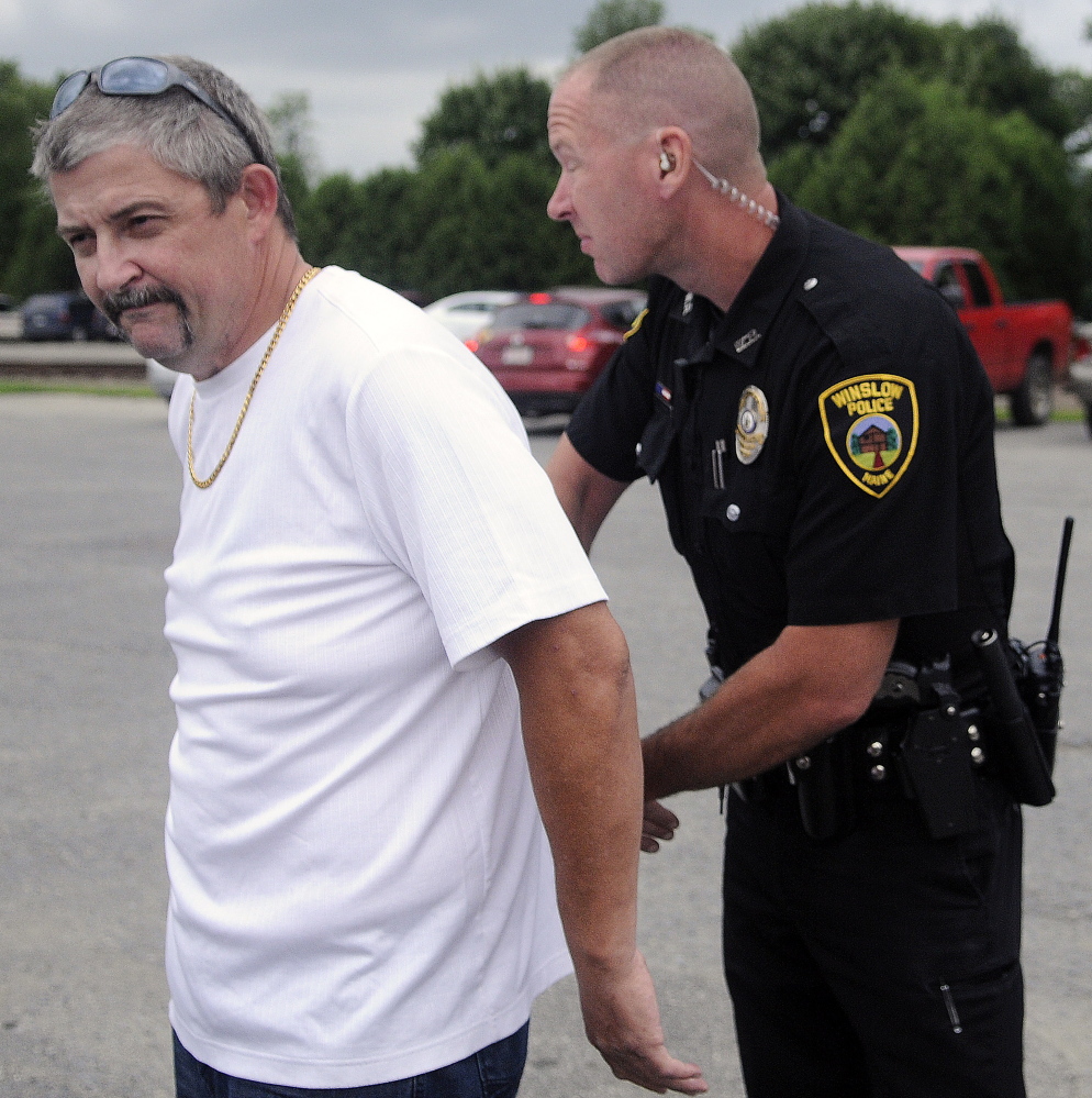 Winslow police Officer John Veilleux handcuffs Frederick Horne Sr. Sunday in the parking lot of Fort Halifax Park in Winslow. Horne was charged with two counts of violating conditions of release when he gave away bride Theresa Rice-Goodrich during her wedding held in the gazebo at the park.