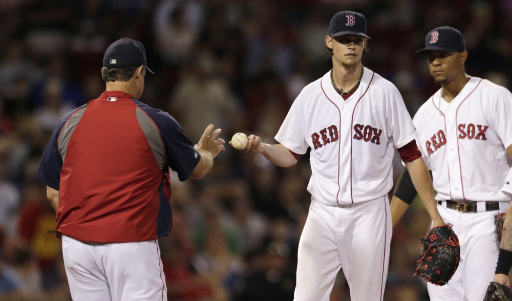 Red Sox starting pitcher Clay Buchholz hands the ball to manager John Farrell as he is taken out of Monday’s game against the Toronto Blue Jays in the sixth inning. Buchholz gave up seven runs, all earned, on seven hits.