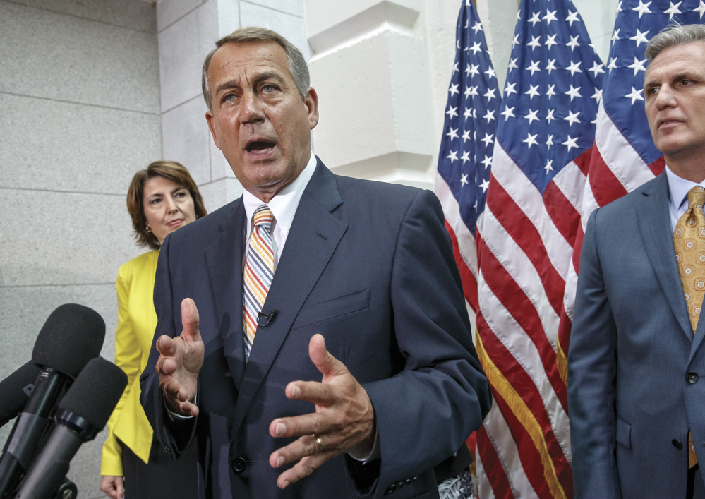 Speaker of the House John Boehner of Ohio, flanked by Rep. Cathy McMorris Rodgers, R-Wash., and incoming Majority Leader Rep. Kevin McCarthy, R-Calif., speaks to reporters on Capitol Hill Tuesday following a Republican strategy session.