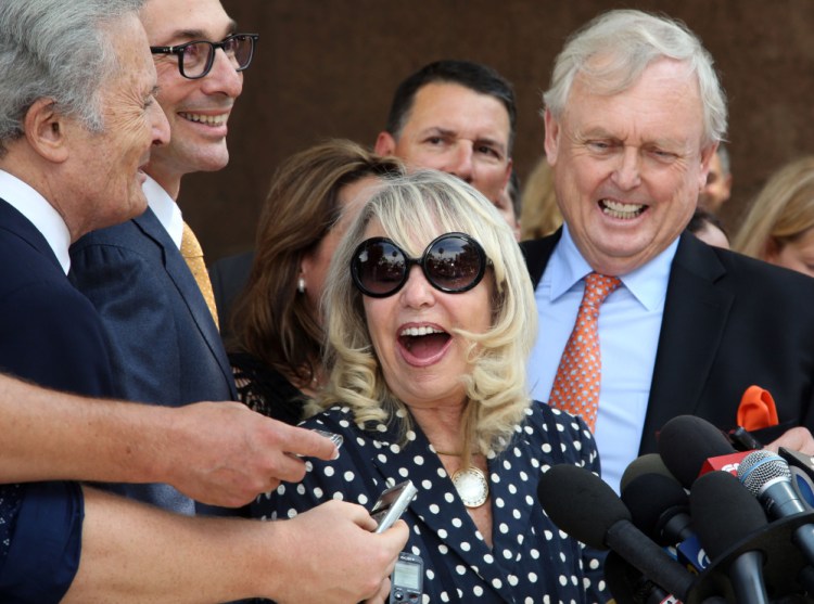 With her attorney Pierce O’Donnell, right, Shelly Sterling, center, talks to reporters after a judge ruled in her favor and against her estranged husband, Los Angeles Clippers owner Donald Sterling, in his attempt to block the $2 billion sale of the NBA basketball team, outside Los Angeles Superior Court, Monday.