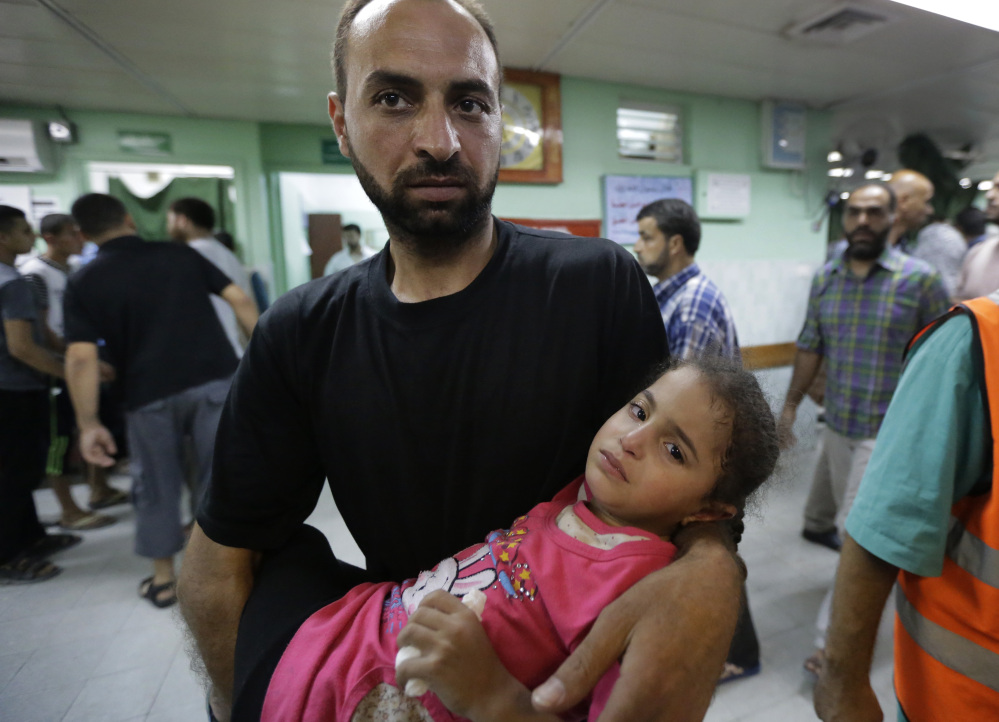 A Palestinian man carries a girl who was wounded in an Israeli strike in the Jebaliya refugee camp into the emergency room of the Kamal Adwan hospital, in Beit Lahiya, northern Gaza Strip, on Tuesday.