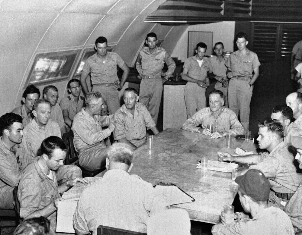 The crew of the Enola Gay is debriefed in Tinian, Northern Mariana Islands on Aug. 6, 1945 after returning from their atomic bombing mission over Hiroshima, Japan. At foreground left, seated at the corner of the table, is Capt. Theodore VanKirk, navigator.