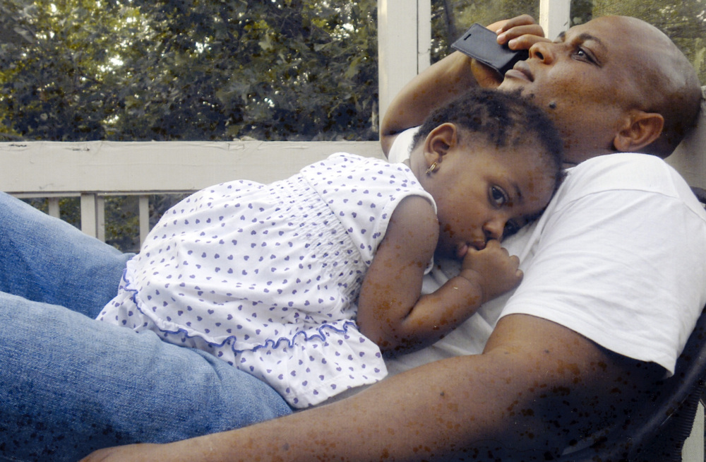 In this undated family photo, Patrick Sawyer is shown with his daughter Ava at their home in Coon Rapids. Sawyer  died from Ebola after traveling from his native Liberia to Nigeria. The Associated Press