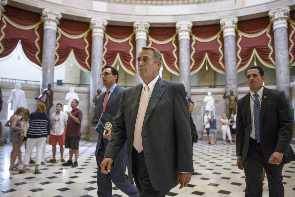 House Speaker John Boehner walks to the House chamber Wednesday as lawmakers prepare to move on legislation to authorize a lawsuit that accuses President Obama of exceeding his powers in enforcing the Affordable Care Act.