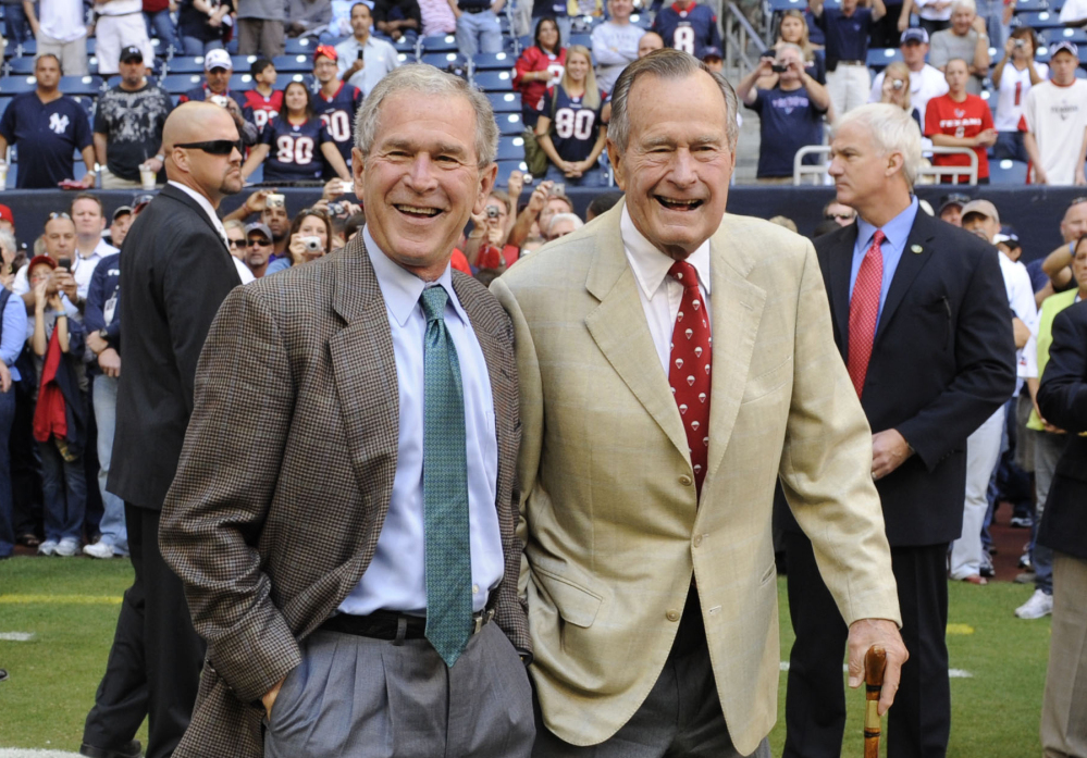 George H.W. Bush, right, and George W. Bush attend a Texans NFL game in Houston in 2009. The elder Bush is one of the few recent presidents not to have written a memoir.