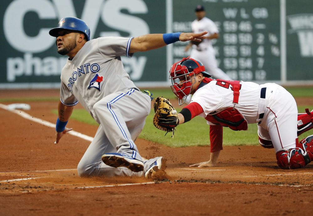 Blue Jays outfielder Melky Cabrera slides safely into home past Red Sox catcher Christian Vazquez, scoring on a fielder’s choice grounder by Juan Francisco in the first inning Fenway Park on Wednesday.