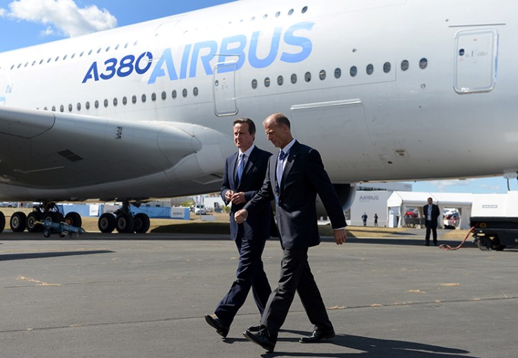 Britain's Prime Minister David Cameron centre, and Tom Enders, the chief executive of Airbus Group, walk by an Airbus A380, during a visit to the 2014 Farnborough Airshow in Hampshire, England, Monday. The Associated Press