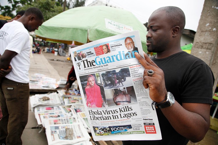 A man reads a local newspaperson a street with the headline Ebola Virus kills Liberian in Lagos, in Lagos Nigeria, Saturday. The Associated Press
