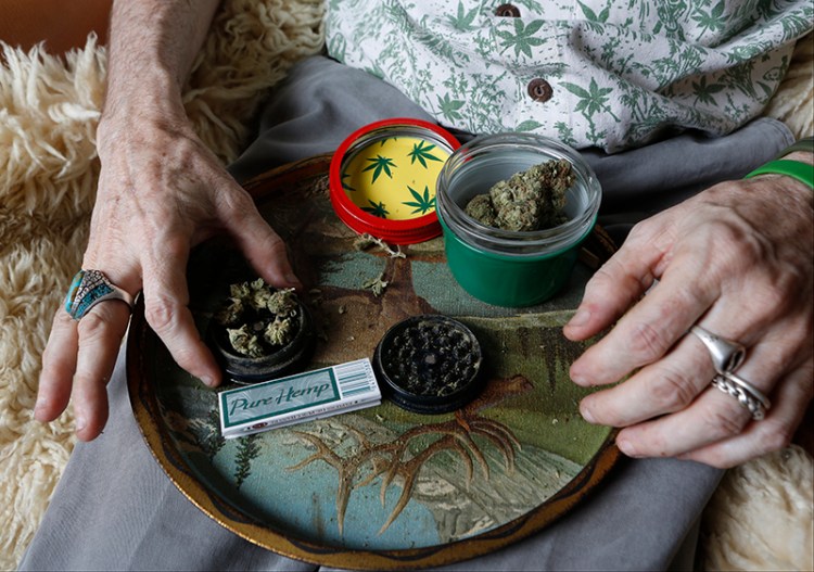 In this April 30, 2014 photo, Bill Britt, who suffers from epileptic seizures and leg pain from a childhood case of polio, prepares a medical marijuana joint at his home in Long Beach, Calif. The Associated Press