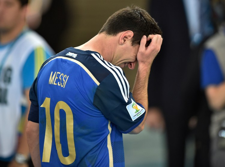 Argentina's Lionel Messi scratches his head as he goes to accept his runners-up medal after Sunday's World Cup final, in which Germany beat Argentina 1-0 and denied Messi the trophy he wanted most.