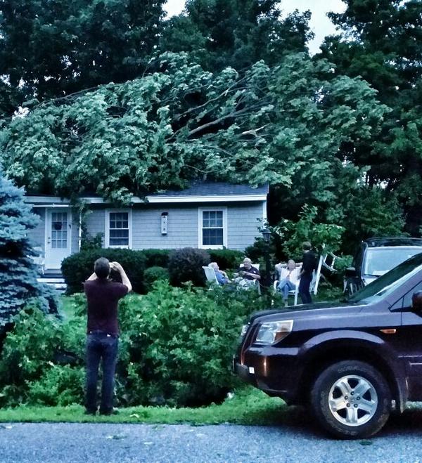 Residents wait outside a house in York that was hit by a falling tree during Tuesday's storm.