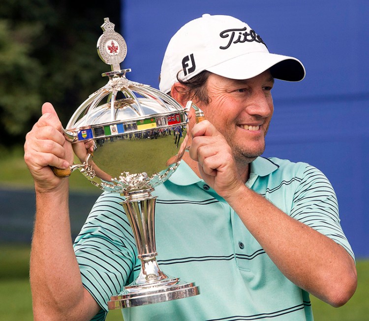 Tim Clark, from South Africa, holds his Canadian Open Championship trophy after final round play at the Canadian Open golf championship, Sunday. The Associated Press