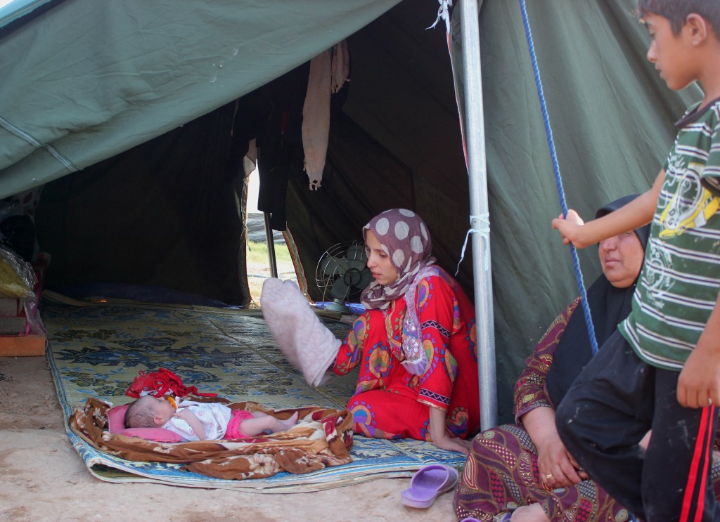 A displaced Iraqi family who fled from Baqouba after advances by Islamic militants, sits in their tent Sunday at a camp in Khanaqin, 90 miles northeast of Baghdad.