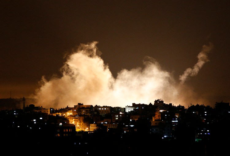 Smoke from flares rises in Gaza City on Thursday. Israel launched a large-scale ground offensive in the Gaza Strip and continued shelling into Friday morning, escalating a 10-day military operation to try to destroy Hamas' weapons arsenal, rocket firing abilities and tunnels under the Palestinian territory's border with Israel.