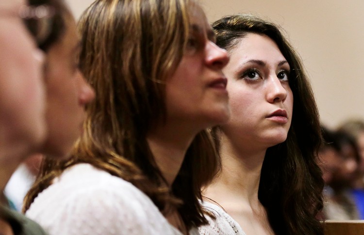 Abigail Hernandez, right, sits with family and friends as she listens to her mother Zenya Hernandez, center, talk with N.H. Senior Assistant Attorney General Jane Young, right, prior to the arraignment of Nathaniel Kibby, 34, of Gorham, N.H. at Conway District Court in Conway, N.H.