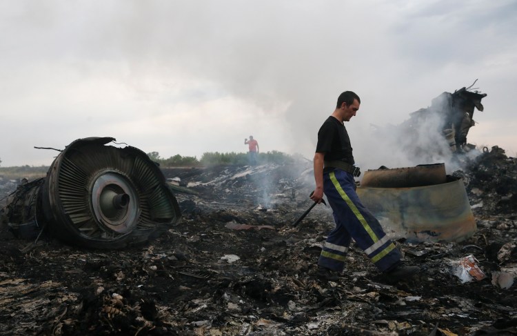 An emergency responder examines the site of the Malaysia Airlines Boeing 777 plane crash near the settlement of Grabovo in the Donetsk region of Ukraine on July 17, 2014.