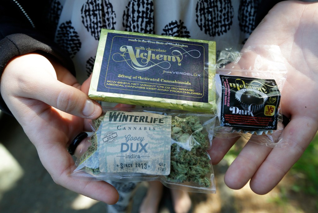 A customer who identified herself as "Tracy" displays marijuana, a pot-infused chocolate bar, and a marijuana truffle that she purchased outside her home from a pot delivery driver working for Winterlife.