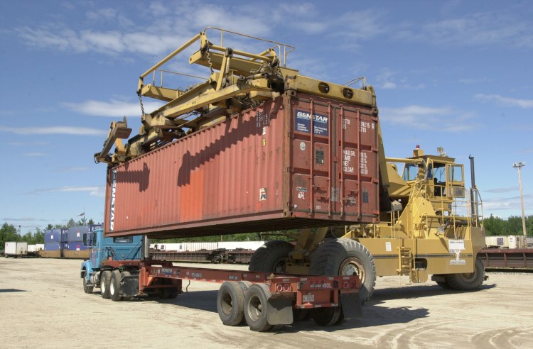 A shipping container at the Maine Intermodal Terminal in Auburn is uncoupled and lifted from a tractor-trailer to be placed on a railroad car in this 2002 photo. At its peak in 1998, about 12,000 containers moved through the terminal, says Chalmers Hardenbergh, publisher of an industry newsletter, but by 2009 the terminal moved only 800 containers. Press Herald file