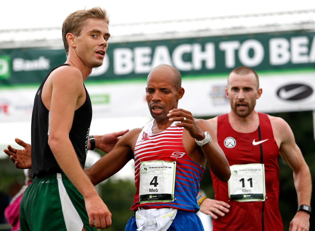 Will Geoghegan of Brunswick receives congratulations from Meb Keflezighi, this year's Boston Marathon winner, after Geoghegan finished the 17th annual TD Beach to Beacon 10k road race as the top Maine male on Saturday. Gabe Souza/Staff Photographer