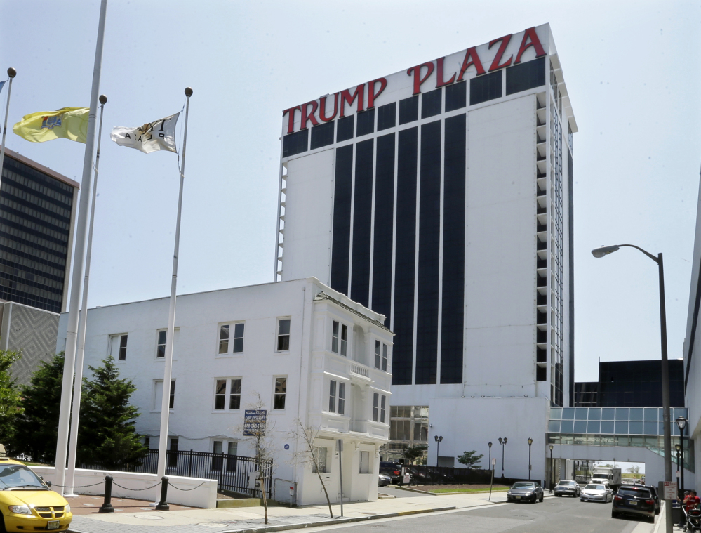 Trump Plaza Hotel and Casino towers over Vera Coking's three story rooming house Wednesday, July 23, 2014, in Atlantic City, N.J. The decrepit boarding home owned by the Atlantic City woman who has been turning down multi-million dollar offers for the building in the shadow of Trump Plaza since the 80’s is now up for auction. With a reserve price of only $199,000, the fate of the house has gone down along with the city’s casino industry. On July 31, the property, at 127 South Columbia Place, will go up for auction. As recently as eight years ago, Donald Trump was willing to pay at least 10 times that amount so he could expand Trump Plaza Hotel and Casino. (AP Photo/Mel Evans)