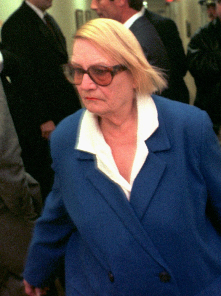 FILE - In this Thursday Feb. 13, 1997, file photo, Vera Coking walks past Donald Trump, partially obscured against wall at left, in a courtroom hallway at Atlantic County Superior Court in Atlantic City, N.J. Coking, who became a folk hero for resisting decades-long efforts by big-name developers like Trump to displace her Atlantic City boardinghouse, is now 91 and, at last, ready to sell. Coking’s boardinghouse goes up for auction Thursday, July 31, 2014, for a $199,000 starting bid. (AP Photo/Allen Oliver, File)