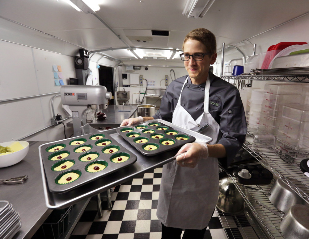 Chef Alex Tretter carries a tray of cannabis-infused peanut butter and jelly cups at Sweet Grass Kitchen, a Denver-based gourmet marijuana edibles bakery. Colorado  regulators seek to make it easier consumers to tell how much pot they are eating.