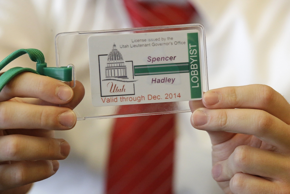 A staff member at the Utah lieutenant governor’s office holds a sample badge lobbyists are required to wear as of Friday at the Utah State Capitol in Salt Lake City.