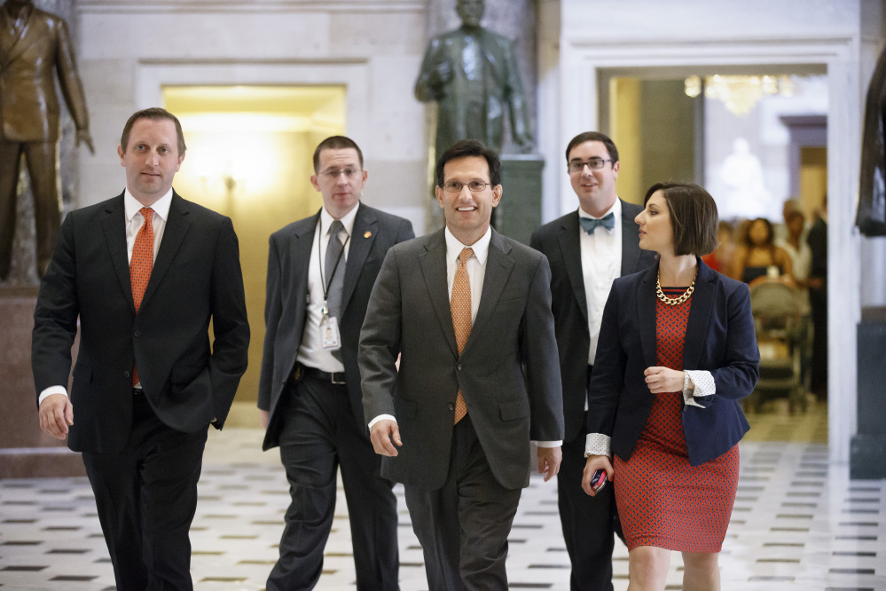 The Associated Press
Rep. Eric Cantor, R-Va., surrounded by his staff as he walks to the House chamber Wednesday, gave up his leadership post Thursday, then announced Friday that he will leave Congress on Aug. 18.