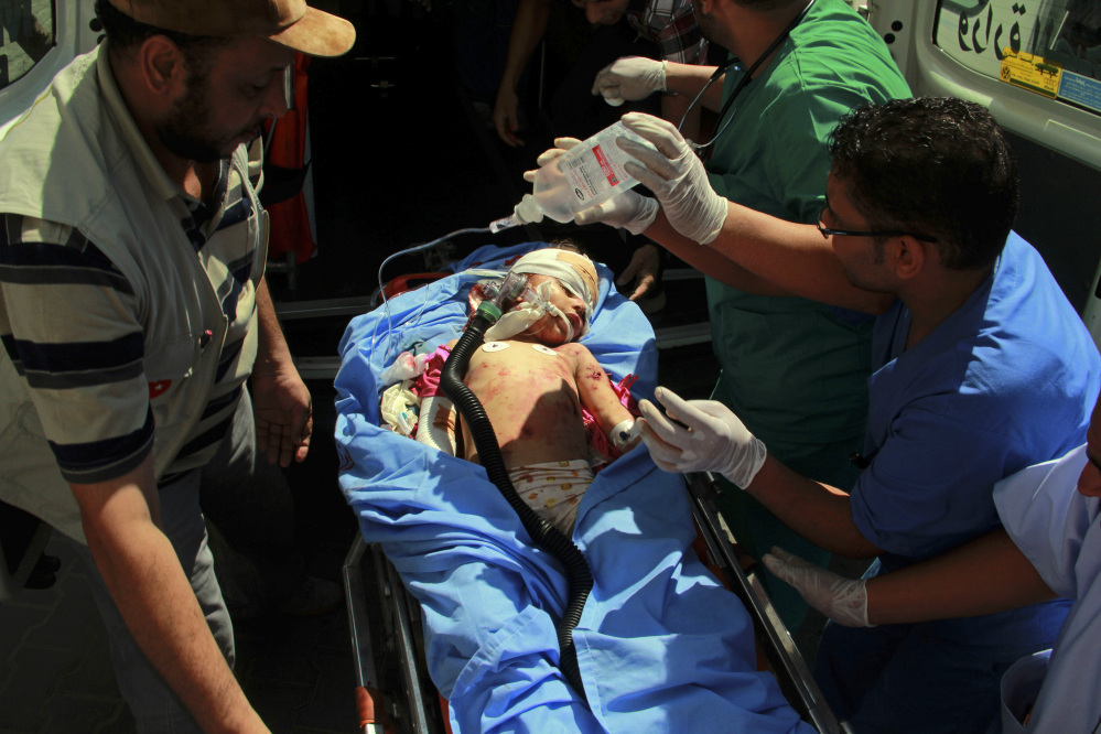 Medics treat a Palestinian child wounded in shelling in Rafah, southern Gaza Strip on Saturday. Israel bombarded Rafah on Saturday as troops searched for an officer they believe was captured by Hamas in an ambush that shattered a humanitarian cease-fire and set the stage for a major escalation of the 26-day-old war.