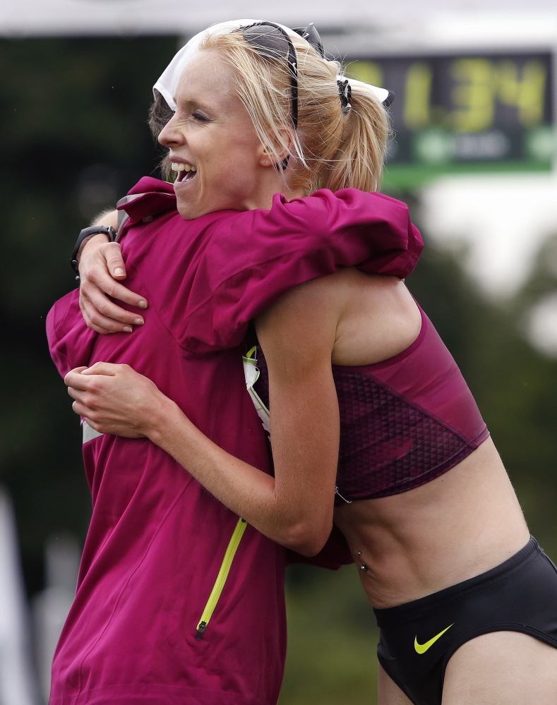 Joan Benoit Samuelson gives a hug to Gemma Steel of Great Britain after Steel finished first in the women’s division of the 17th annual TD Beach to Beacon 10K on Saturday.