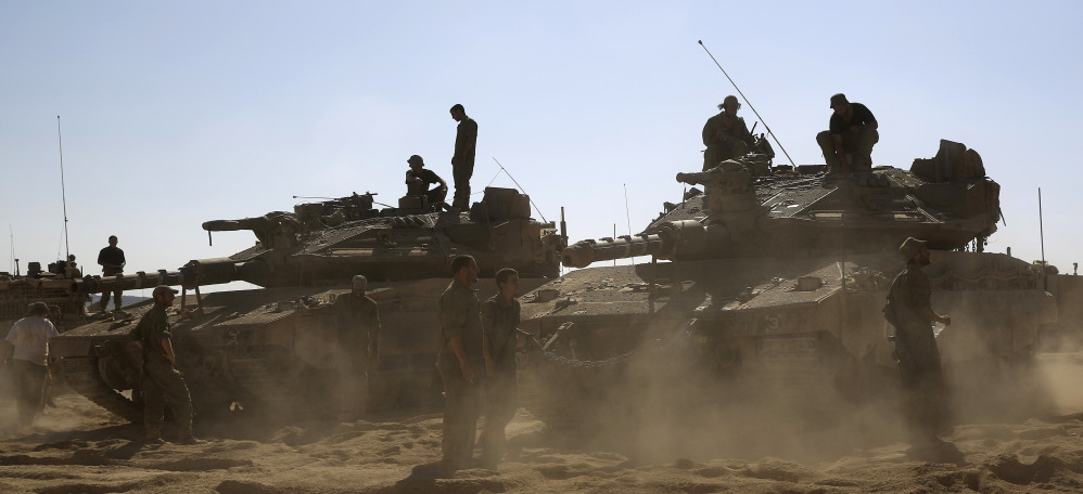 Israeli soldiers gather near the border with Gaza on Saturday. The conflict has killed about 1,700 Palestinians, mostly civilians, 63 Israeli troops and three Israeli civilians.