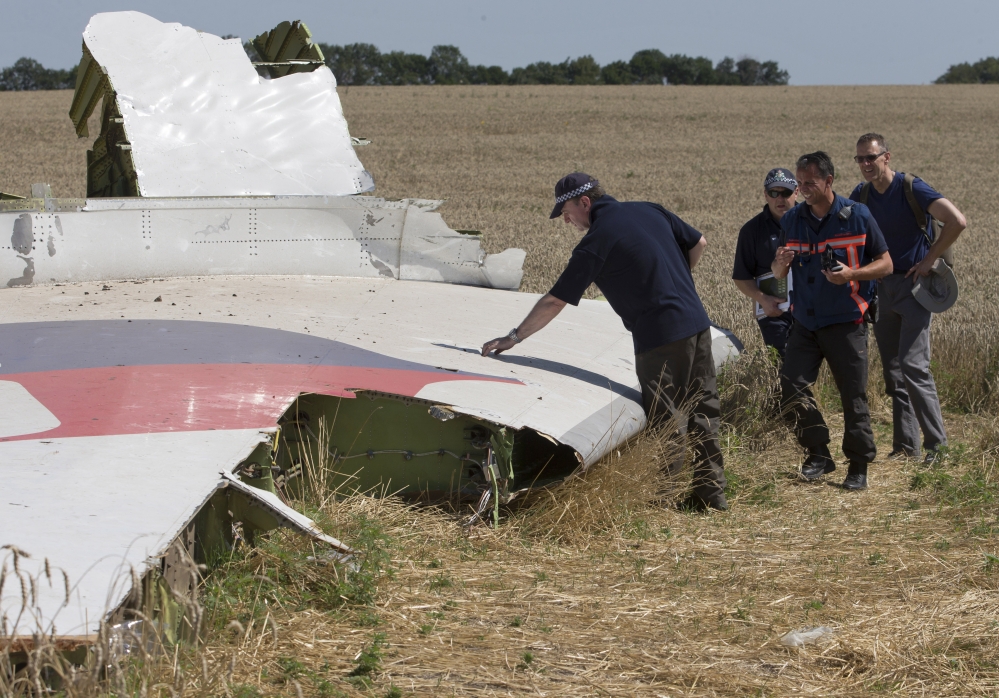 Investigators examine wreckage of the Malaysia Airlines jet near Hrabove, Donetsk region, eastern Ukraine, on Friday.