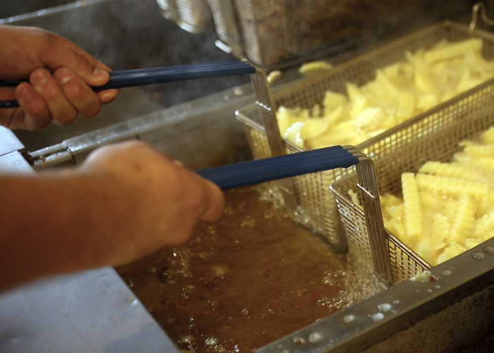 Andrew Thayer cooks a batch of french fries at at Pier Fries, a business that has operated in Old Orchard Beach since 1932.
Amelia Kunhardt/Staff Photographer
