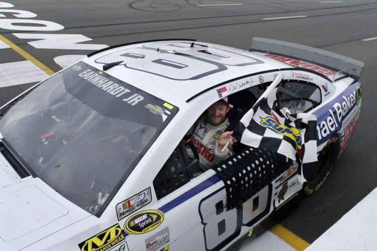 Dale Earnhardt Jr. (88) holds the checkered flag after winning the NASCAR Sprint Cup Series auto race at Pocono Raceway, Sunday, in Long Pond, Pa.
