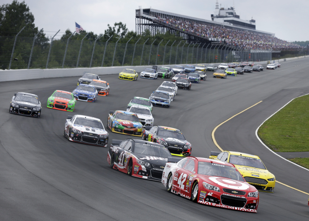 Kyle Larson (42) leads a pack of cars at the start of the NASCAR Sprint Cup Series auto race at Pocono Raceway, Sunday, in Long Pond, Pa.