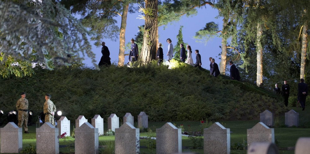 Heads of state and others walk up to the top of a hill to lay flowers during the ceremony Monday at the Saint-Symphorien cemetery in Belgium.