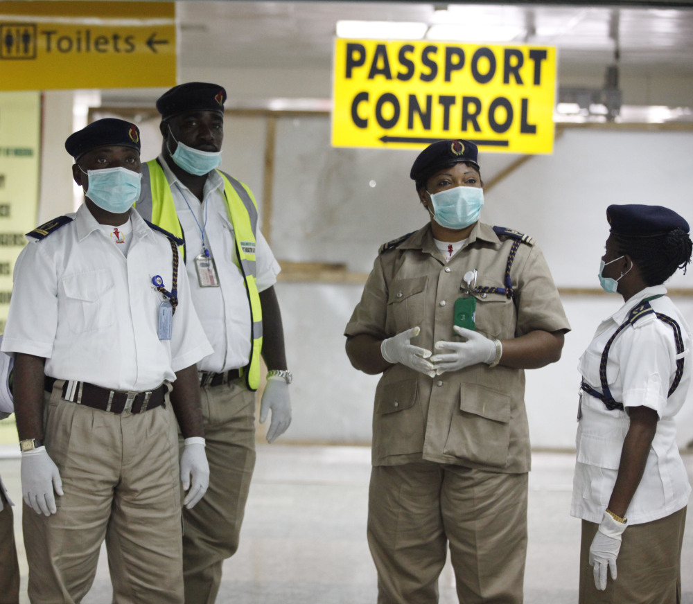 Nigerian health officials wait to screen passengers at Murtala Muhammed International Airport in Lagos, Nigeria, on Monday. The confirmation of a second Ebola case in Africa’s most populous country is seen as an alarming setback.