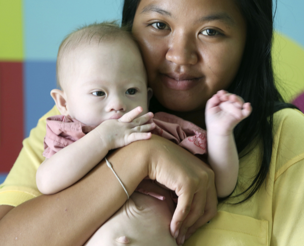 Pattaramon Chanbua poses with Gammy, her baby boy born with Down syndrome in Thailand. Pattaramon says she would welcome the return of the healthy twin that was born with Gammy.