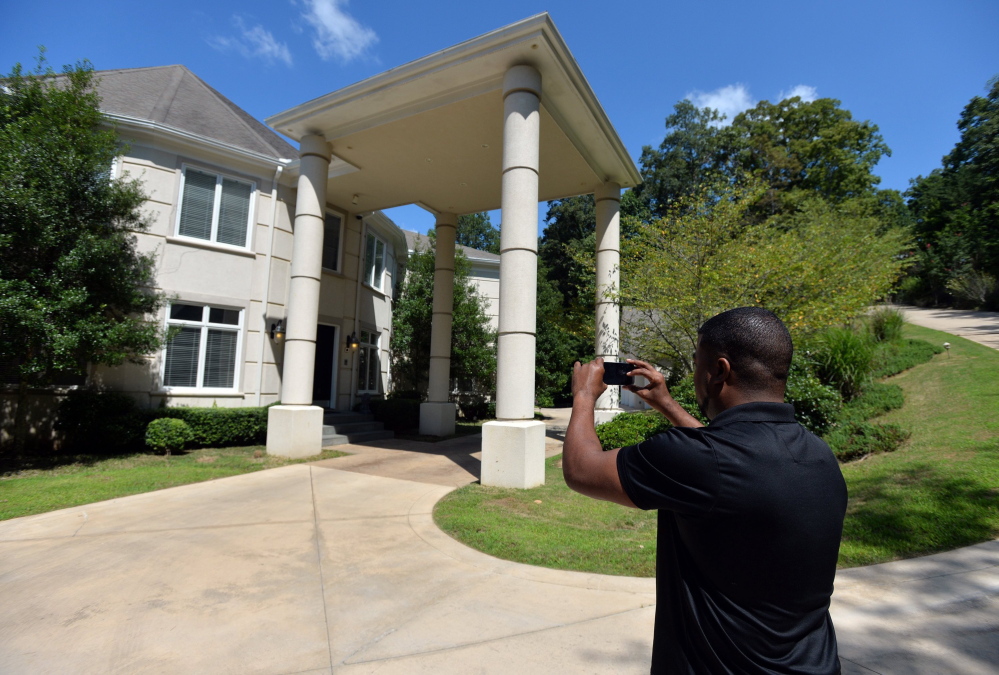 Craig Craft takes a photo of the $1.7 million house he “manages” through a program called Showhomes of Atlanta. He gives the otherwise empty and impersonal estate a warm, inoffensive, lived-in look. In return, he gets to “live a life of luxury,” while splitting the $1,200 monthly rent with a roommate.
