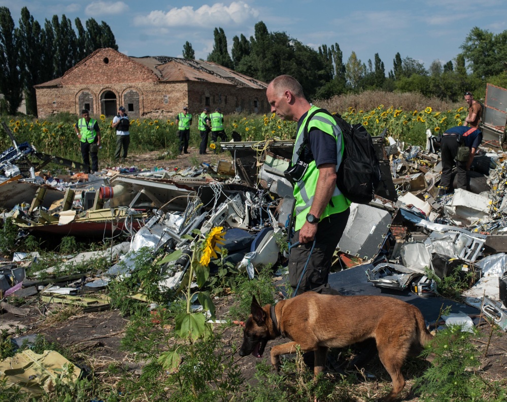 Australian, Malaysian and Dutch investigators examine the site of the downed Malaysian jet Tuesday near the village of Rossipne, Donetsk region, eastern Ukraine.