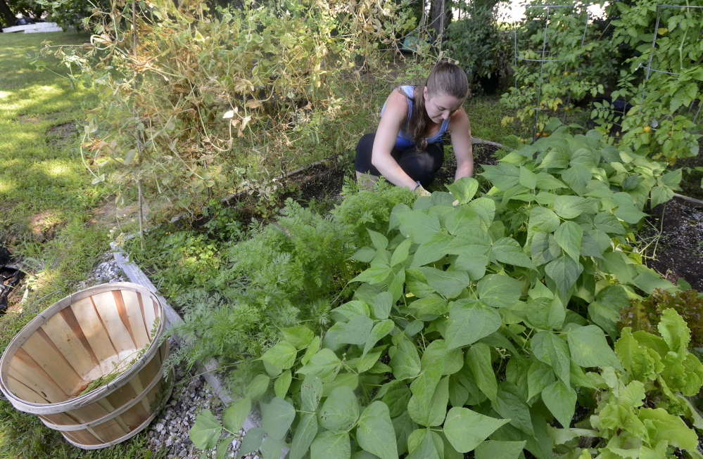 Stephanie Ladd works in the garden behind her home in Yarmouth.