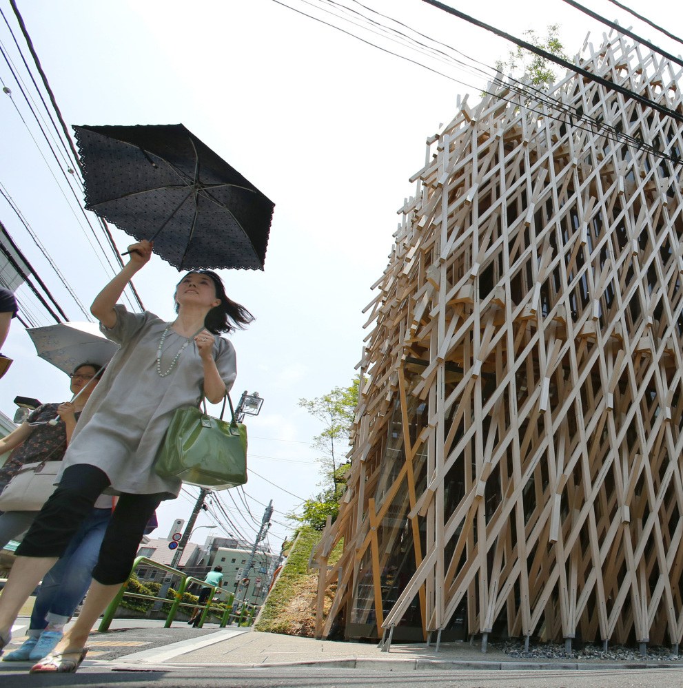 Pedestrians pass Sunny Hills, known as the “Pineapple House,” designed by Japanese architect Kengo Kuma.