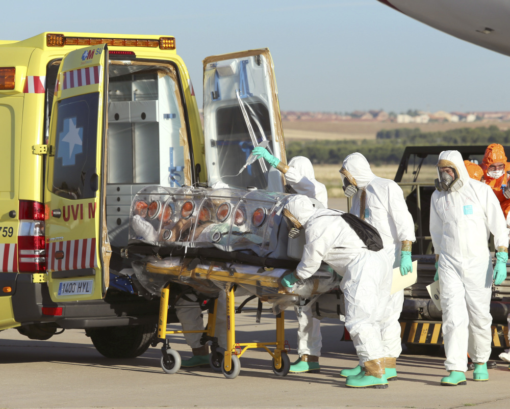 Aid workers and doctors transfer Miguel Pajares, a Spanish priest who was infected with the Ebola virus while working in Liberia, from a plane to an ambulance. Photo provided by the Spanish Defense Ministry.