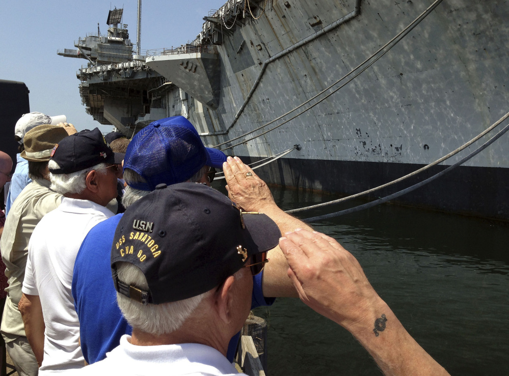 Veterans of the decommissioned aircraft carrier USS Saratoga salute the vessel during a farewell ceremony Friday at Naval Station Newport in Rhode Island.