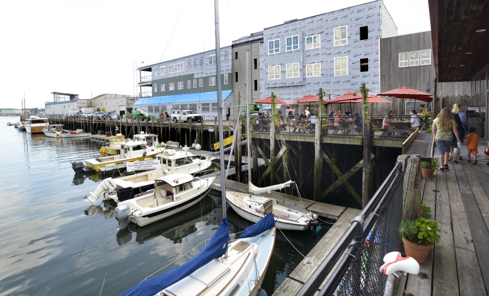 A building under construction on Maine Wharf in Portland will house a new restaurant and offices. Casco Bay Lines terminal is on the left and Flatbread restaurant is on the right.