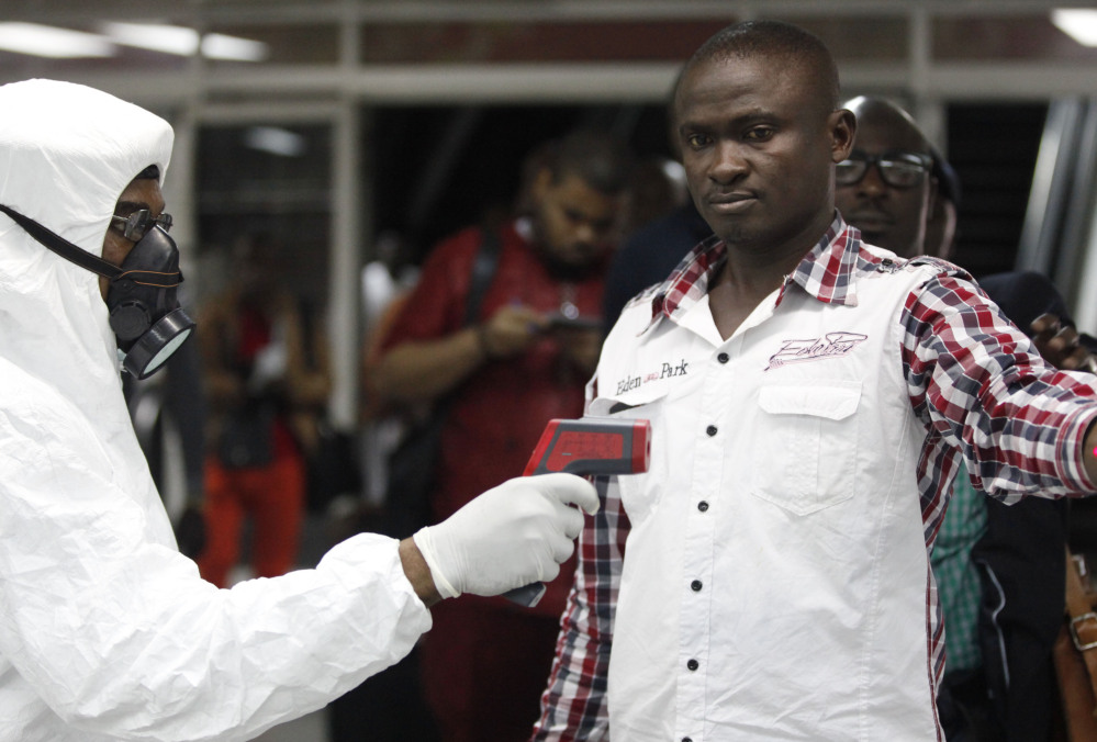 A Nigerian official uses a thermometer on a worker at the airport arrivals hall in Lagos. Ebola emerged in Guinea in March and has spread to Sierra Leone, Liberia and Nigeria.