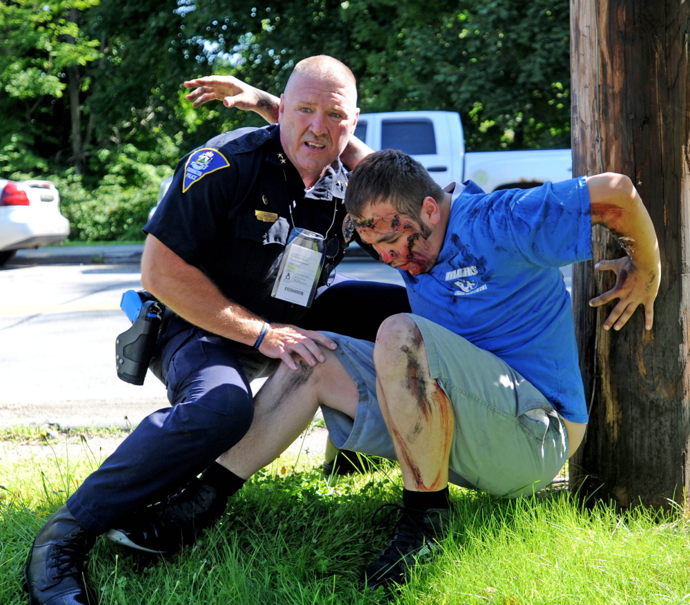 Farmington Police Chief Jack Peck helps a man portraying a victim of a car bombing during a Homeland Security training exercise at the University of Maine at Farmington.