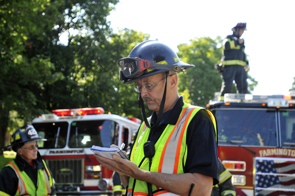 Farmington firefighter, Steve Bunker, takes notes during simulated emergency in Farmington on Friday.